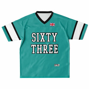 A teal short-sleeve V-neck jersey with 'SIXTY THREE' printed in large white varsity letters across the chest, featuring a small Union Jack flag on the upper right chest and white sleeve stripes with black trim.